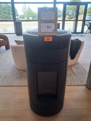 a black trash can sitting on the floor in front of a window