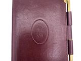 a close up of a leather notebook with a pen on it
