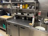 une grande cuisine en inox avec beaucoup de plans de travail