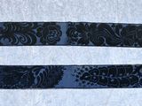 two black ribbons with designs on them on a white surface