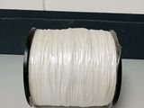 une image représentant une bobine de fil blanc posée sur une table