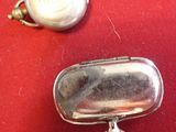 a silver case with a keychain on a red cloth