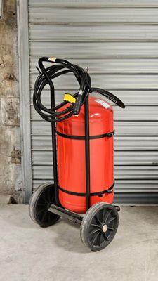 un extincteur et un diable devant la porte d'un garage