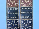two old books sitting on top of each other on a table