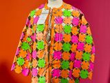 a close up of a mannequin with a colorful jacket on it