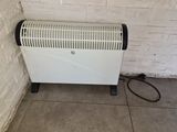 an image of a white electric heater in a corner