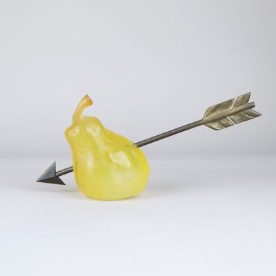 un gros plan d'une poire jaune d'où sort une flèche