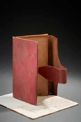 un livre ouvert posé sur une feuille de papier, elle-même posée sur une table