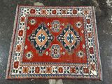 un tapis oriental orange et bleu posé sur un sol en béton