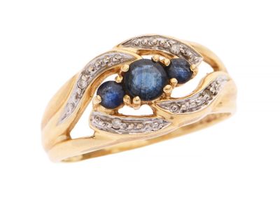 gros plan d'une bague en or avec saphirs et diamants