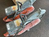 two chainsaws sitting on the floor next to a desk