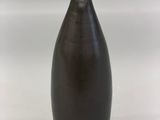 a black vase that is sitting on a white surface