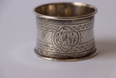 une vieille serviette en argent, ornée d'un monogramme sur fond blanc