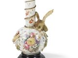 un vase surmonté d'un oiseau, posé sur un socle
