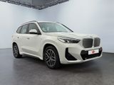 a white bmw x1 parked in a showroom