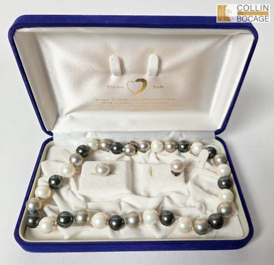 un bracelet de perles blanches et noires dans un coffret bleu
