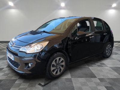 la voiture noire est garée sur un sol en damier dans le garage