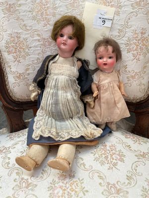 deux poupées assises ensemble sur une chaise