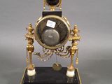 a clock that is sitting on a stand with a key