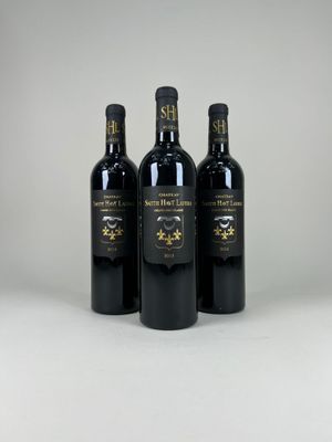 trois bouteilles de vin posées sur une table blanche