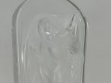 an etched glass vase with a woman holding a bird on it ' s head