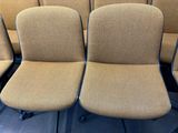 Plusieurs chaises sont alignées en rang dans une pièce vide.