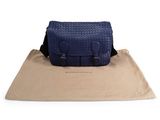 navy blue leather messenger bag on a tan canvas bag