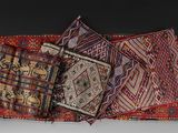 three pieces of colorful rugs on a table with a black background
