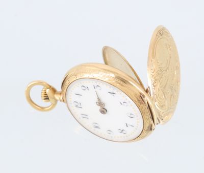 une montre de poche en or ancien sur fond blanc, accompagnée d'une pièce de monnaie