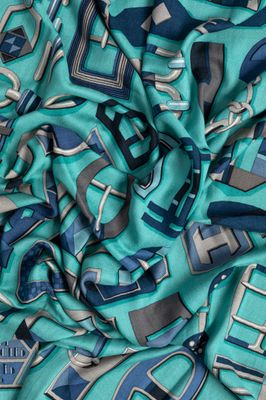 a close up of a green and blue scarf with a geometric design