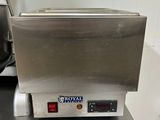 une photo d'une friteuse professionnelle posée sur un plan de travail en inox