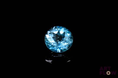 a close up of a blue diamond on a black surface