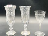 three wine glasses sitting on a table next to each other