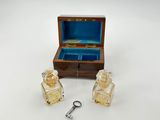 une petite boîte en bois contenant deux flacons de parfum et une clé