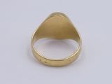 a close up of a gold signet ring on a white surface