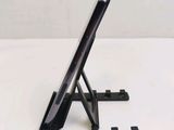 a tablet computer sitting on a stand on a table