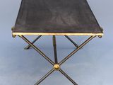 a black and gold side table with brass legs and a leather top