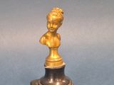 a bronze busturine of a boy on a marble base