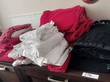 a dresser with a bunch of clothes on top of it