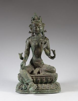 une statue en bronze représentant une femme assise sur un lotus