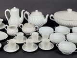 a lot of white dishes and cups on the table