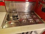 une plaque de cuisson en acier inoxydable et un évier dans une cuisine