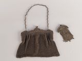 an old brown purse with a chain handle and a small bag with a handle
