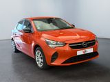 the orange car is parked in a large room with a black floor