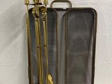 two brass colored metal fireplace tools sitting on top of a table