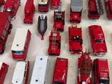 a lot of red toy trucks that are sitting on a table