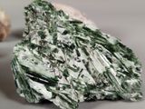 some green and white crystals on a white surface next to a piece of bread