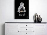 a black and white photograph of a lego man on a black background