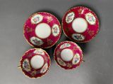 three cups and saucers with floral designs on them on a table