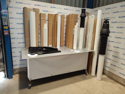 de nombreux rouleaux de papier posés sur une table près d'un mur